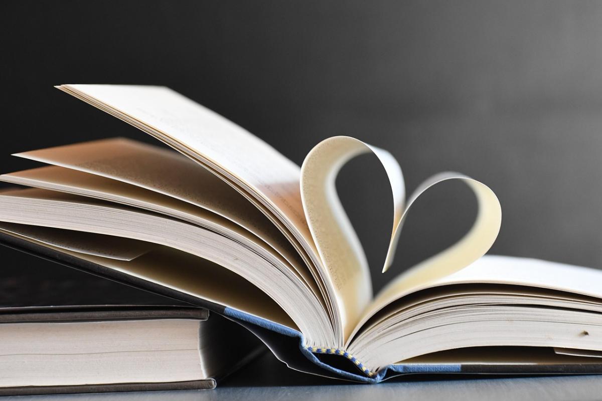 Image of two books stacked.  The top book is open and the pages are folded to make a heart.